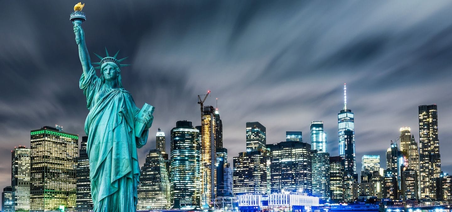 Statue of Liberty with background of the city at night.