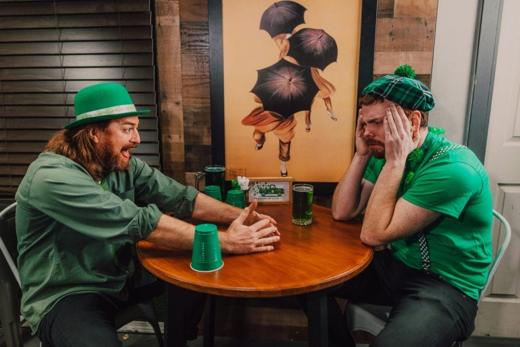 Two friends enjoying some green drinks in a pub
