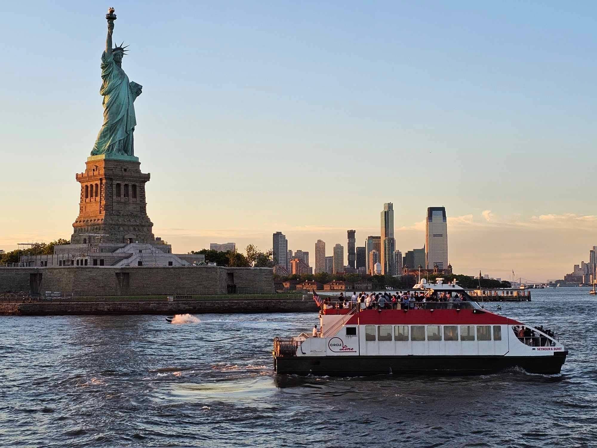 Passengers enjoy a boat ride with the Statue of Liberty majestically standing in the background