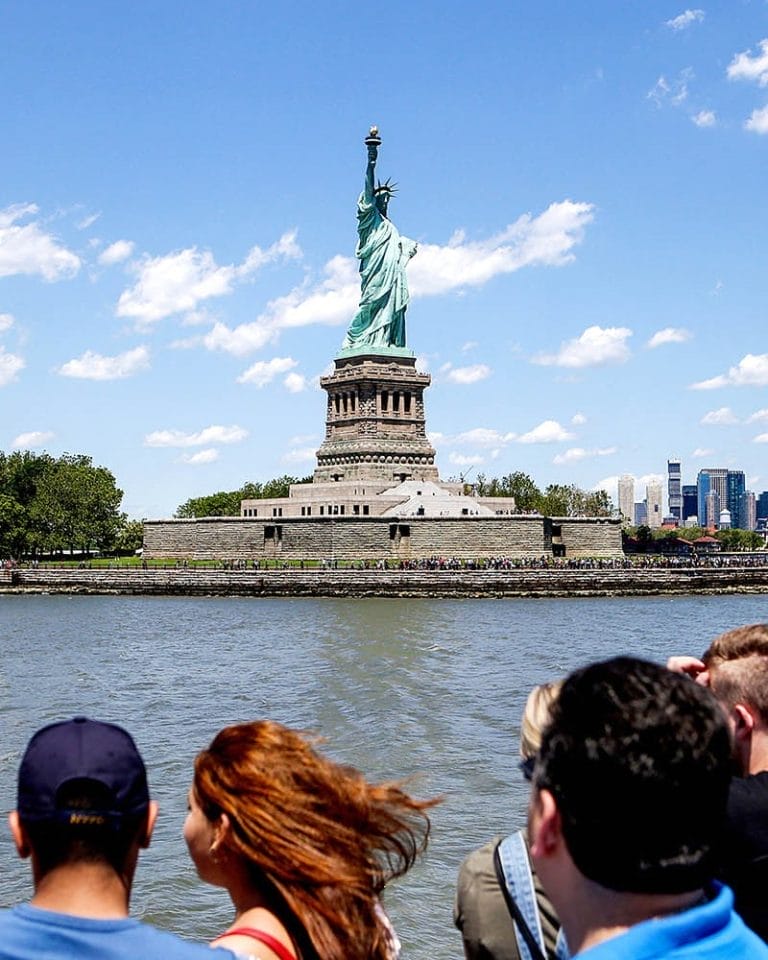 People on a boat heading to the Statue of Liberty