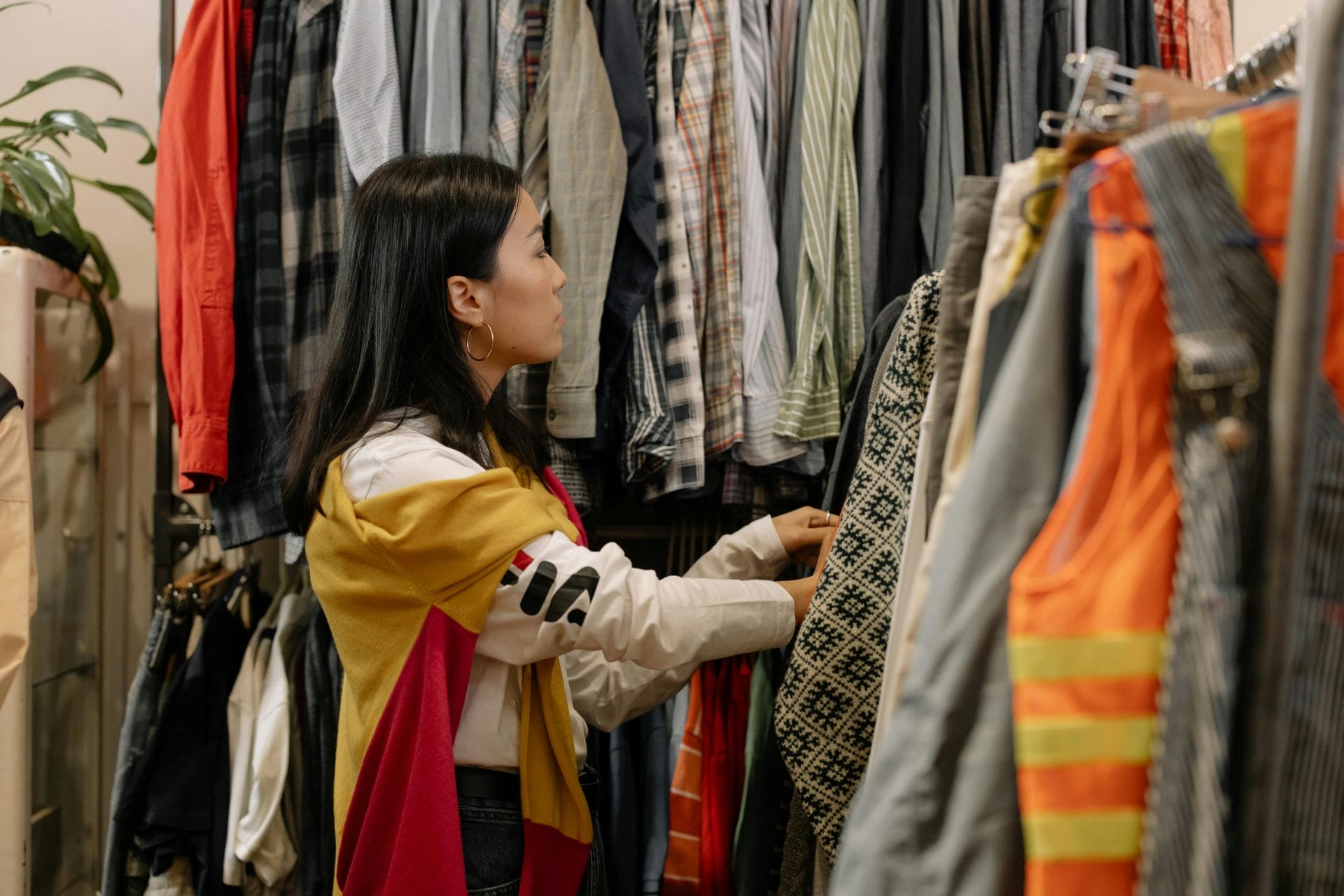 a woman looking through a clothing rack