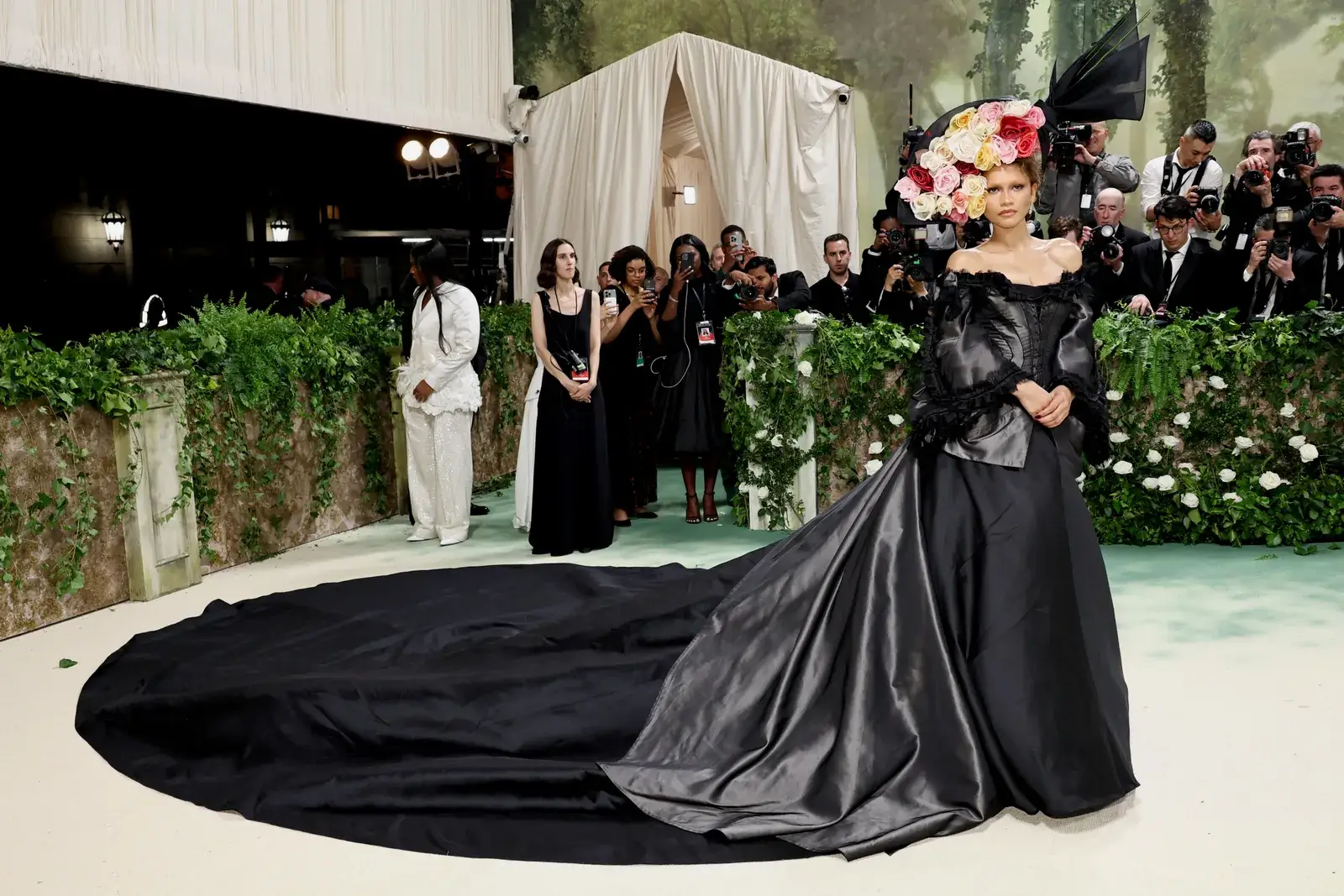 Zendaya in a black dress with flower hat. Met Gala 2025 confirmed celebrities