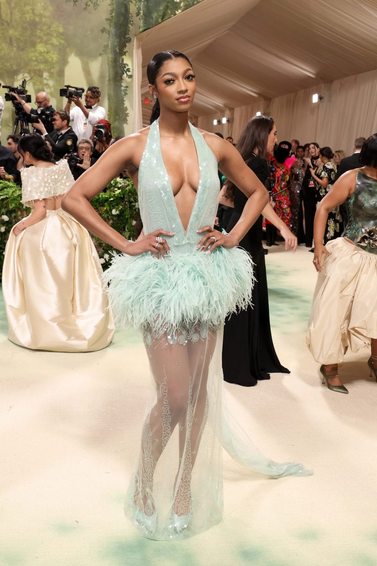 Angel Reese poses at the Met Gala in a plunging mint green dress with feathered skirt and sheer embroidered train. Image from Vogue.com for the blog post "Met Gala 2025: Celebrities, Red Carpet, Theme & More."