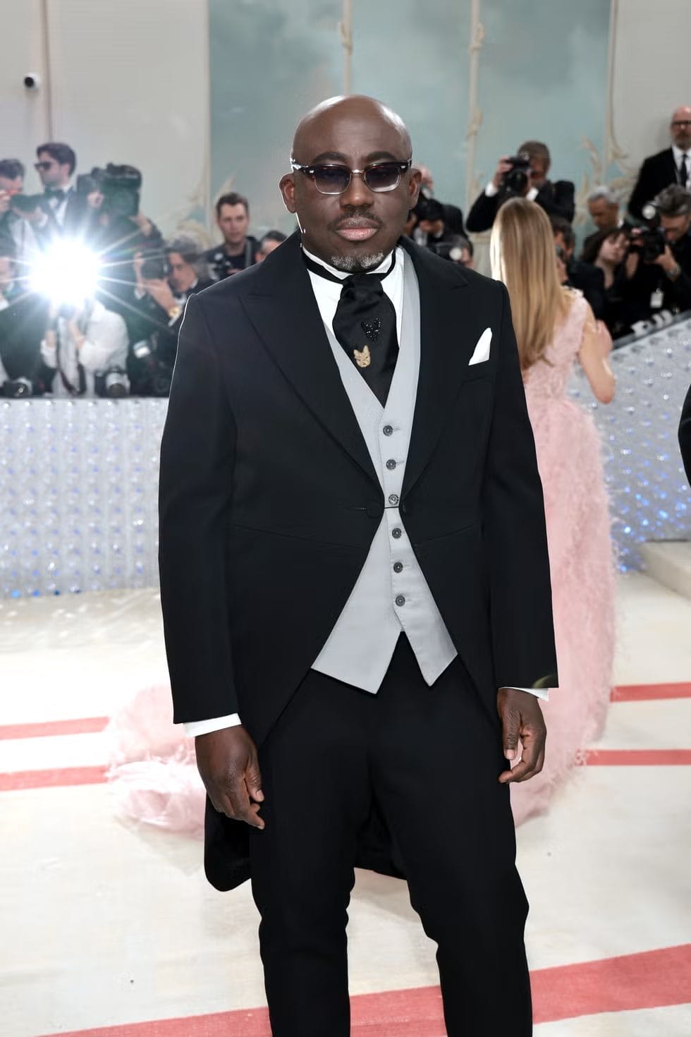 Edward Enninful at the Met Gala wearing a classic black tailcoat with a light grey vest, black cravat, and sunglasses. Featured in the blog post "Met Gala 2025: Celebrities, Red Carpet, Theme & More."