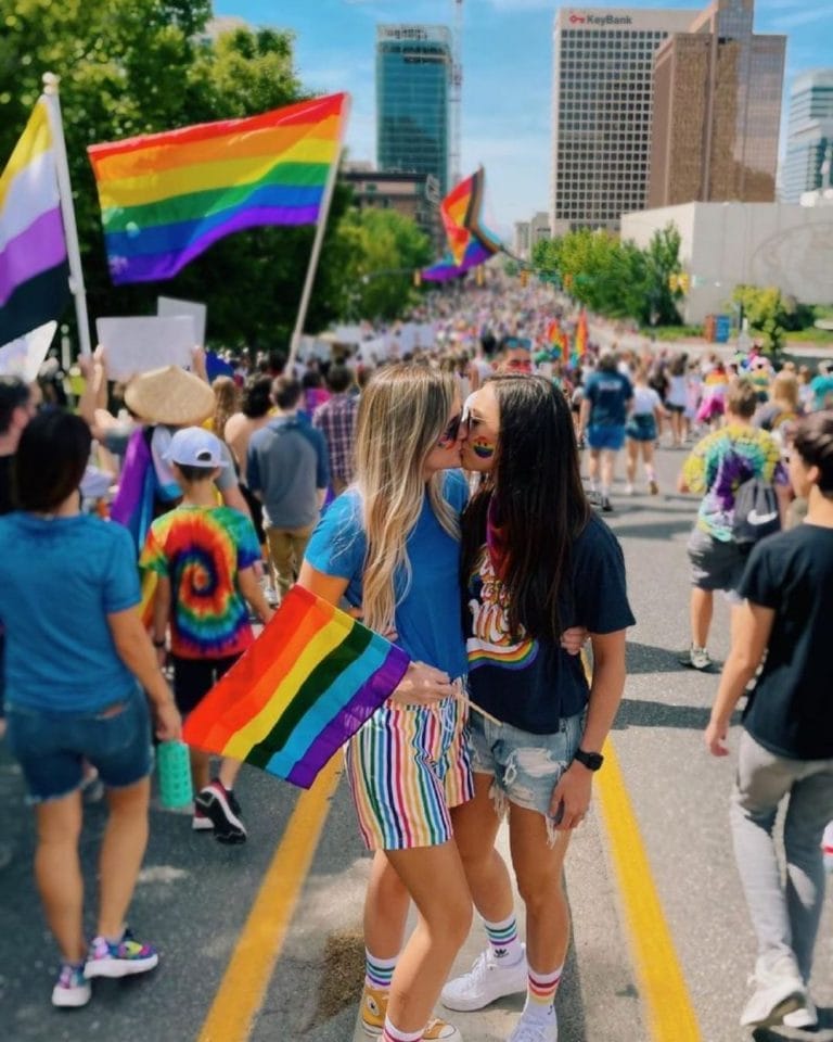 Two individuals holding Pride flags at a Pride Festival